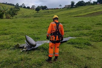 Ein Feuerwehrmann vor einem Wrackteil: Bei einem Flugzeugabsturz sind nach Medienberichten sieben Menschen gestorben.