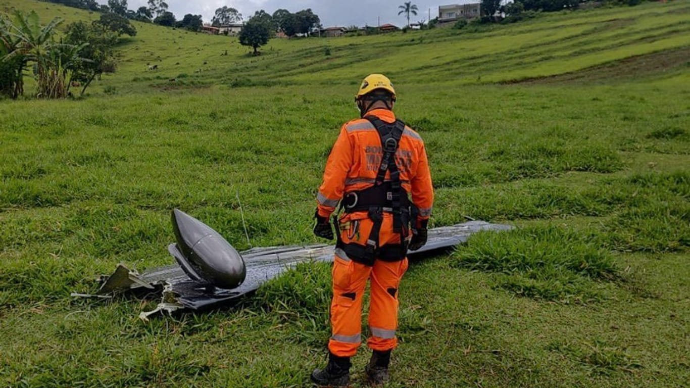 Ein Feuerwehrmann vor einem Wrackteil: Bei einem Flugzeugabsturz sind nach Medienberichten sieben Menschen gestorben.