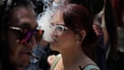 Eine junge Frau stößt Rauch aus (Archivbild): Ärzte halten die Legalisierung von Cannabis für fatal für gefährdete Jugendliche,