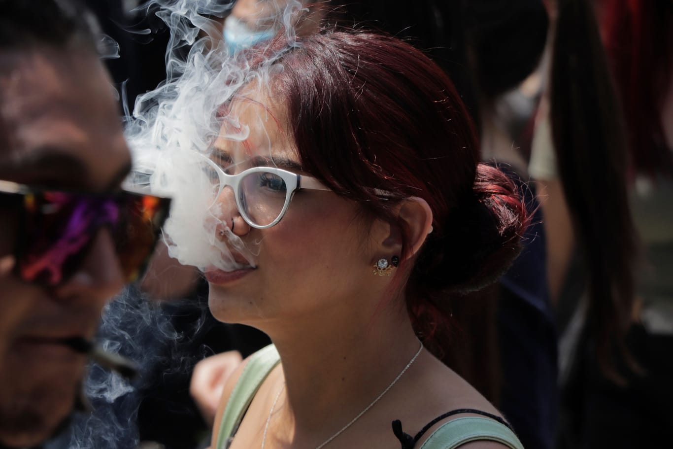 Eine junge Frau stößt Rauch aus (Archivbild): Ärzte halten die Legalisierung von Cannabis für fatal für gefährdete Jugendliche,