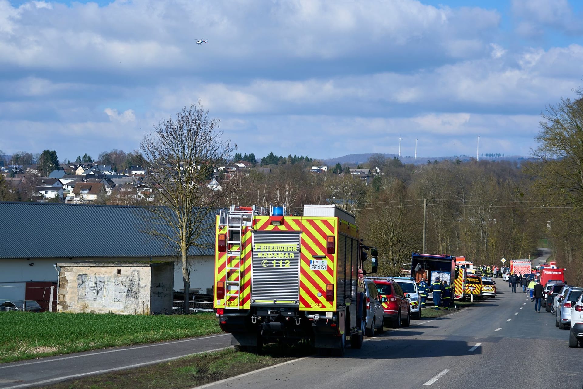 Einsatzkräfte von Feuerwehr und Polizei stehen auf einer Landstraße in Hadamar: Ein Gasleck konnte den dritten Tag in Folge nicht geschlossen werden.