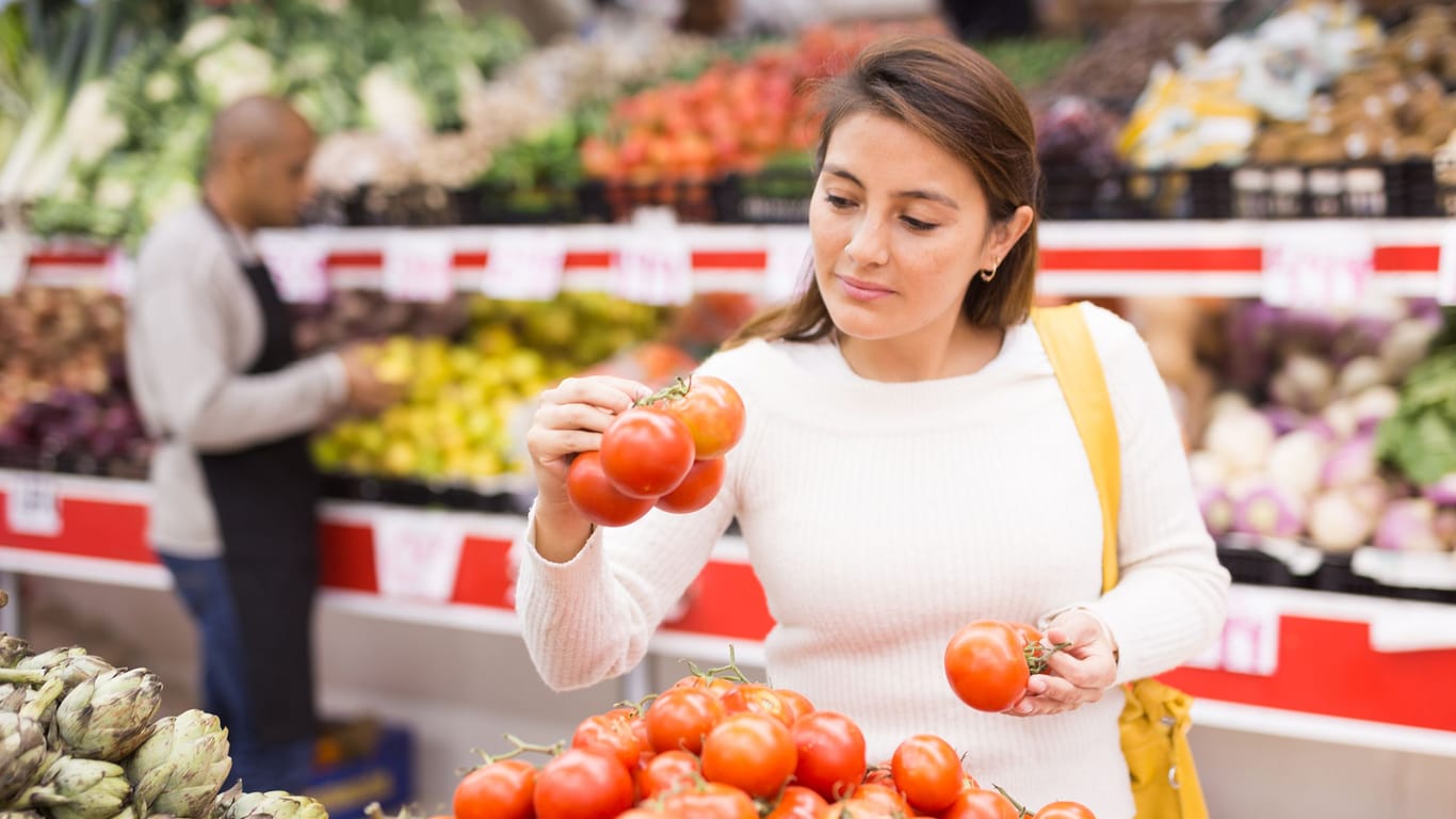 Beautiful latin woman in produce section of supermarket