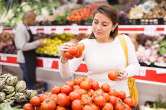 Beautiful latin woman in produce section of supermarket