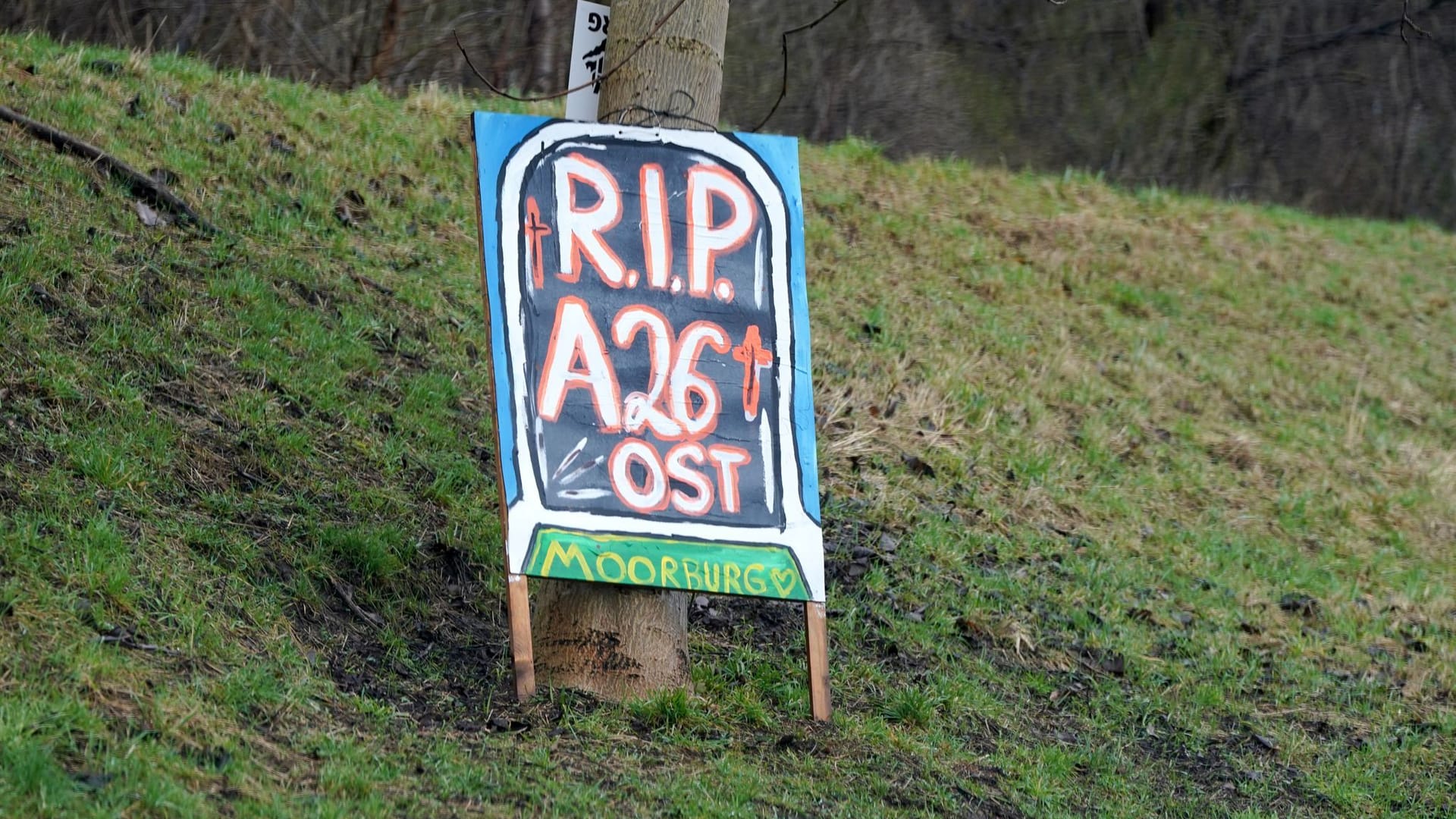 Blick auf ein Protestplakat mit der Aufschrift "R.I.P. A26 Ost. Moorburg" (Archivbild): Es hängt an einem Baum im Stadtteil Moorburg. Blick auf ein Protestplakat mit der Aufschrift "R.I.P. A26 Ost. Moorburg" (Archivbild): Es hängt an einem Baum im Stadtteil Moorburg.