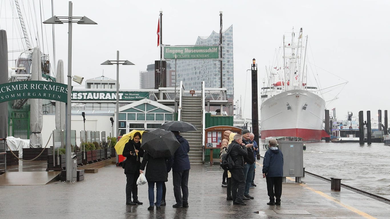Passanten gehen bei Regenwetter an den Landungsbrücken: Hamburgs Winter war zu nass, zu warm und zu dunkel.
