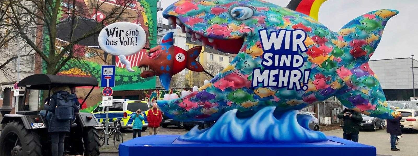 Ein kleiner "rechter" Fisch wird von der Mehrheit der Deutschen verschluckt: "Wir sind mehr", steht auf dem Großen. Zudem trägt seine Flosse die Farben der deutschen Nationalflagge.