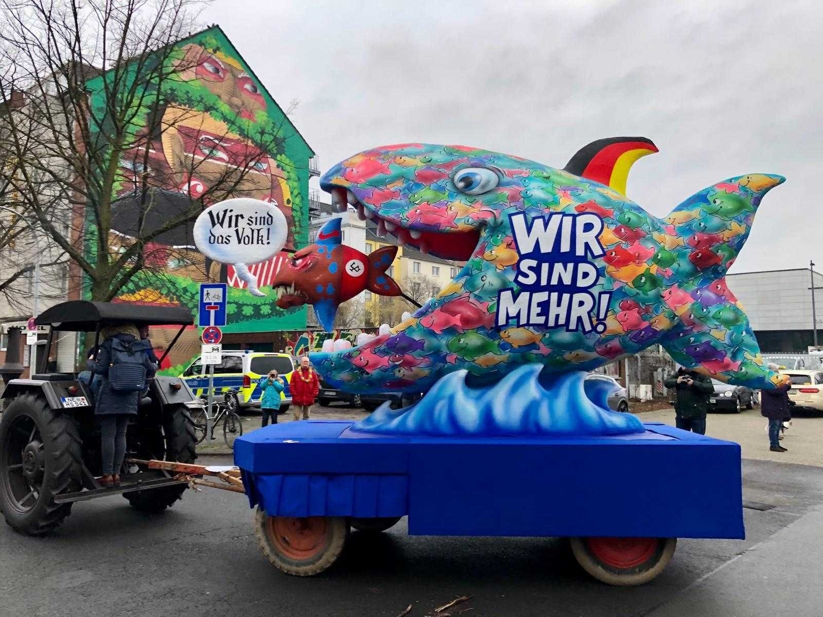 Ein kleiner "rechter" Fisch wird von der Mehrheit der Deutschen verschluckt: "Wir sind mehr", steht auf dem Großen. Zudem trägt seine Flosse die Farben der deutschen Nationalflagge. Ein kleiner "rechter" Fisch wird von der Mehrheit der Deutschen verschluckt: "Wir sind mehr", steht auf dem Großen. Zudem trägt seine Flosse die Farben der deutschen Nationalflagge.