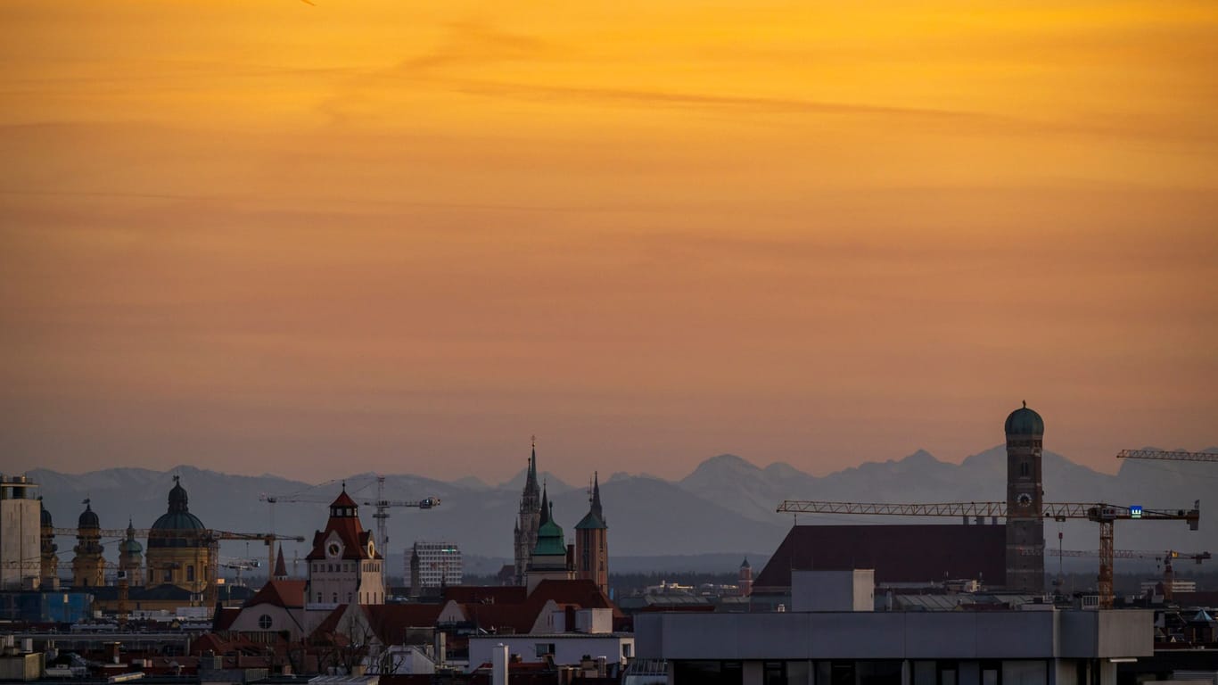 Die Kulisse der bayerischen Landeshauptstadt am Montagabend: Im Hintergrund sind die schneebedeckten Alpen zu sehen.
