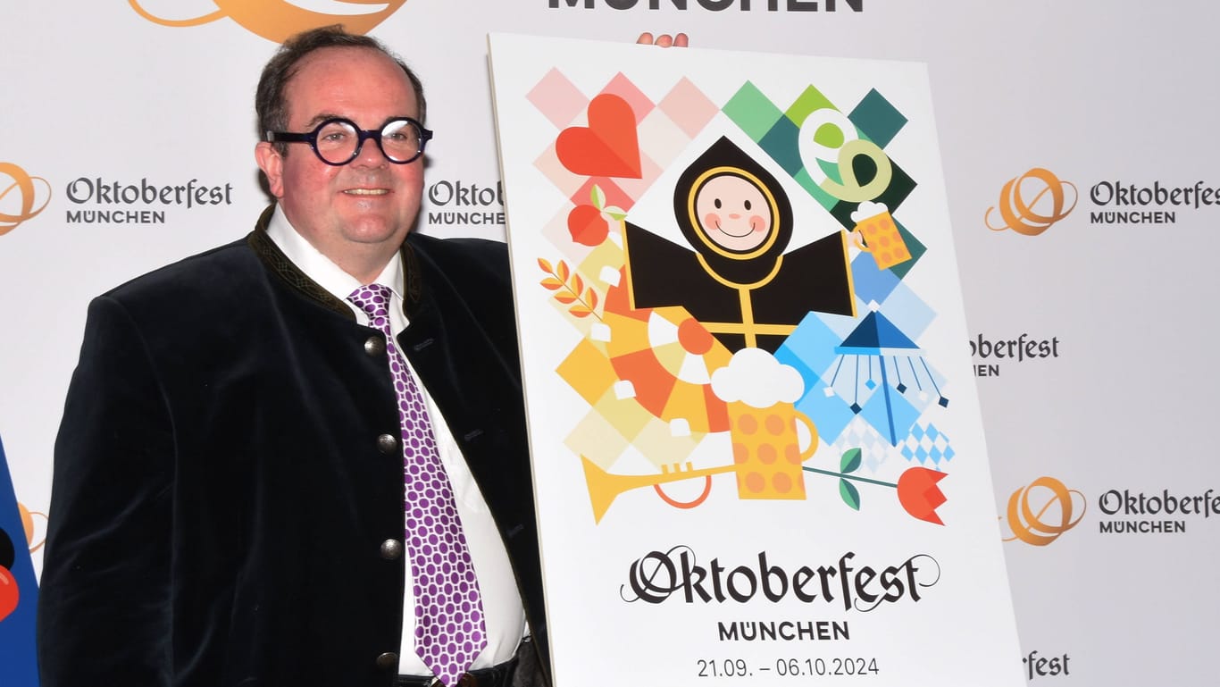 Wiesn-Chef Clemens Baumgärtner präsentiert stolz das neue Oktoberfest-Plakat für 2024.
