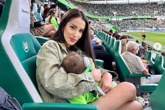 Steffani Jenz, Ehefrau von Wolfsburg-Profi Moritz Jenz, mit ihrem Sohn bei einem Heimspiel des VfL.