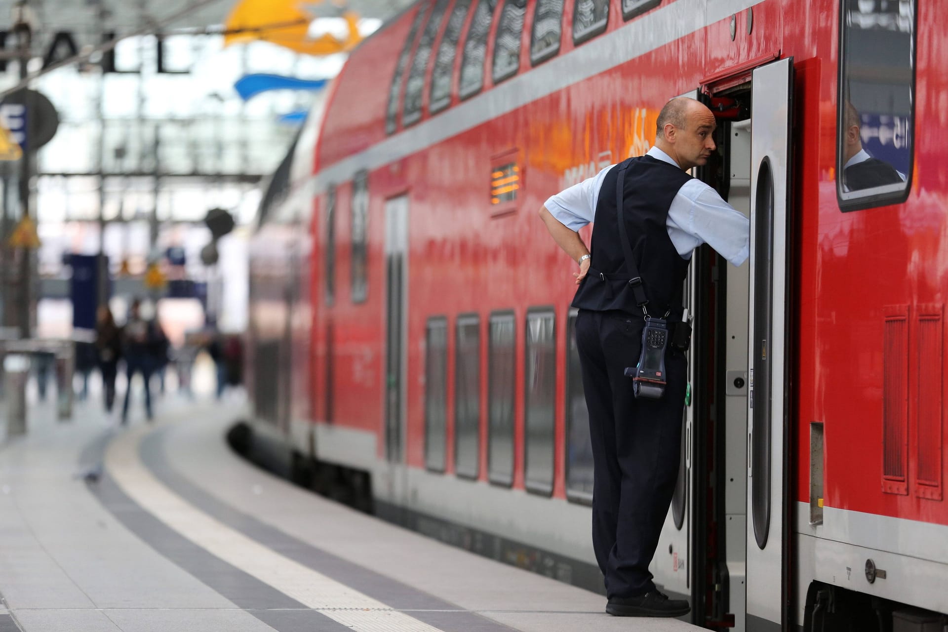 Ein Zugbegleiter wartet auf die Abfahrt (Symbolbild): Die Deutsche Bahn stellt fast 4000 neue Angestellte ein.