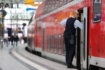 Ein Zugbegleiter wartet auf die Abfahrt (Symbolbild): Die Deutsche Bahn stellt fast 4000 neue Angestellte ein.