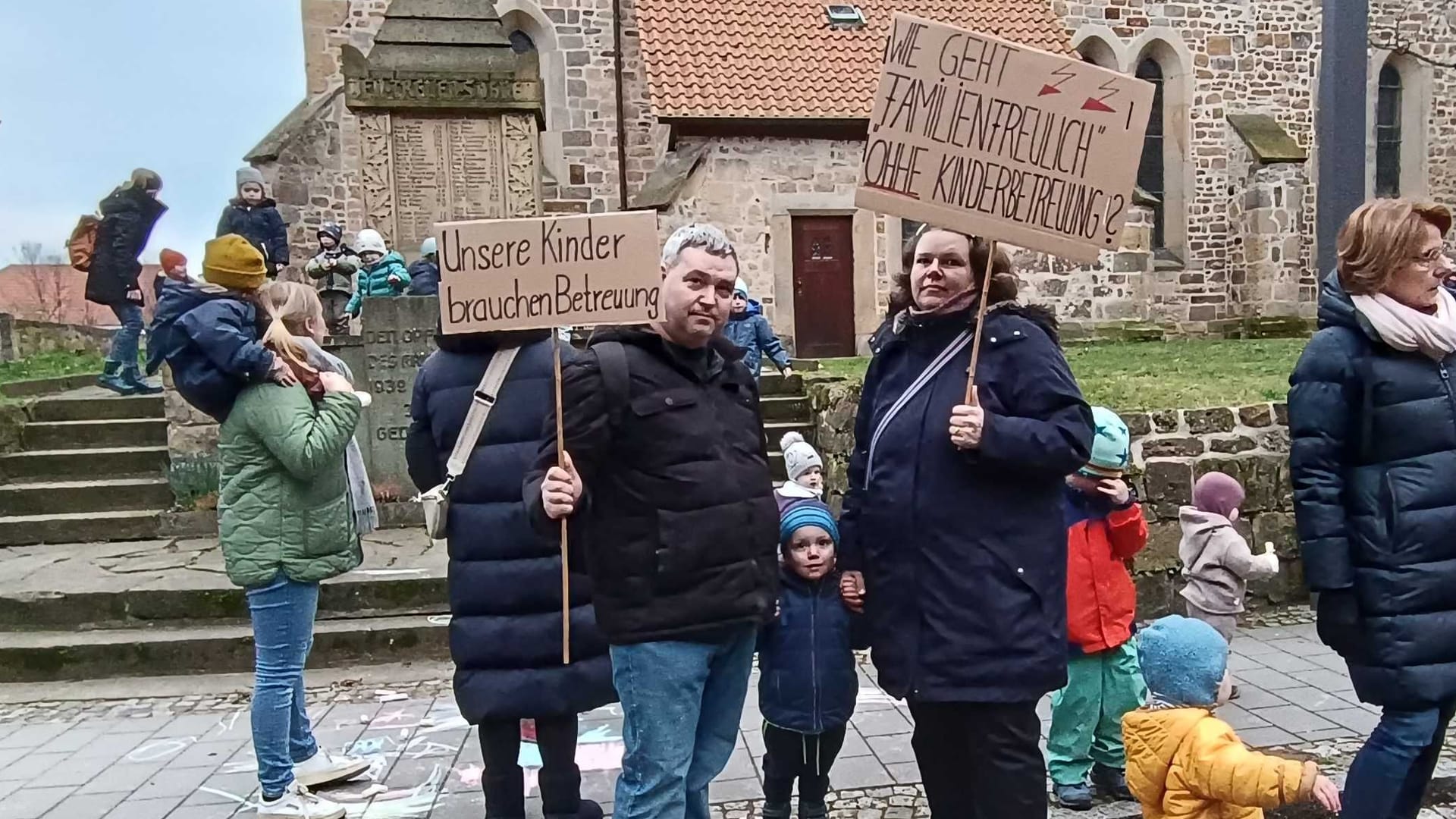 Christine M. demonstriert mit ihrem Ehepartner und Kindern vor dem Rathaus: Die Entscheidung hätte massive Auswirkungen auf ihre finanzielle Situation.