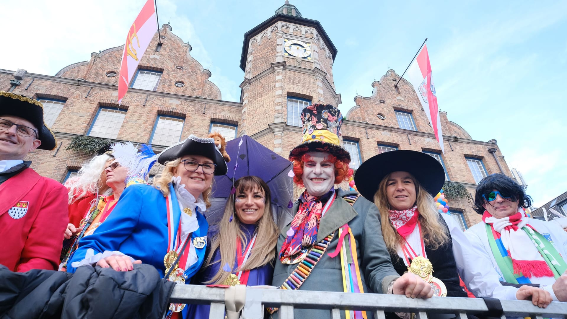 OB Stephan Keller (Mitte, CDU) als verrückter Hutmacher. Links von ihm seine neue Partnerin Meike Folkerts, rechts NRWs stellvertretende Ministerpräsidentin Mona Neubaur (Grüne).