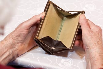 Eine ältere Frau hält ein leeres Portemonnaie in der Hand (Symbolbild): Immer mehr Senioren in Hamburg brauchen Sozialhilfe.