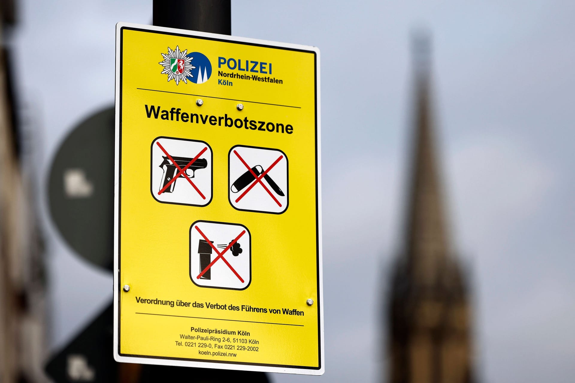 Ein Schild weist auf eine Waffenverbotszone in Köln hin (Symbolbild): In NRW ist die Anzahl von Delikten im Bereich der Straßenkriminalität rückläufig.