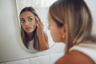 Frau schaut in den Spiegel