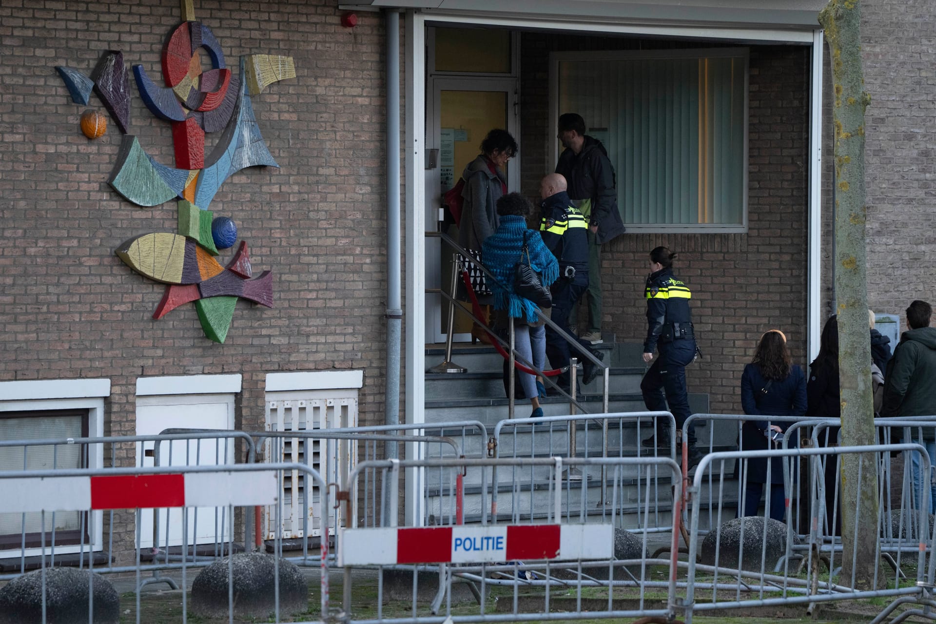 Polizeibeamte betreten das Hochsicherheitsgebäude des Gerichts, in dem in Amsterdam der Prozess gegen eine berüchtigte Drogenbande stattfindet.