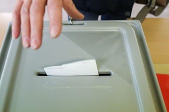 Eine Frau wirft ihren Stimmzettel in die Wahlurne