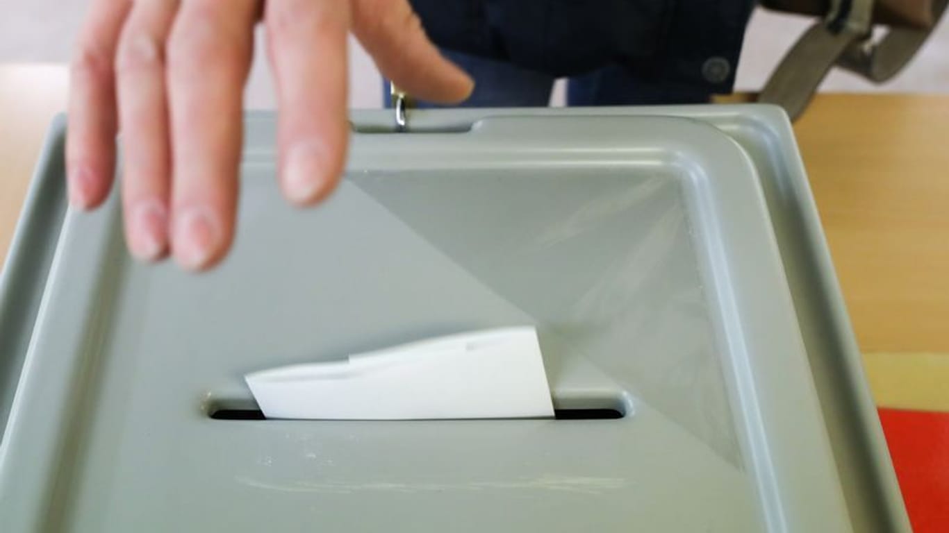 Eine Frau wirft ihren Stimmzettel in die Wahlurne