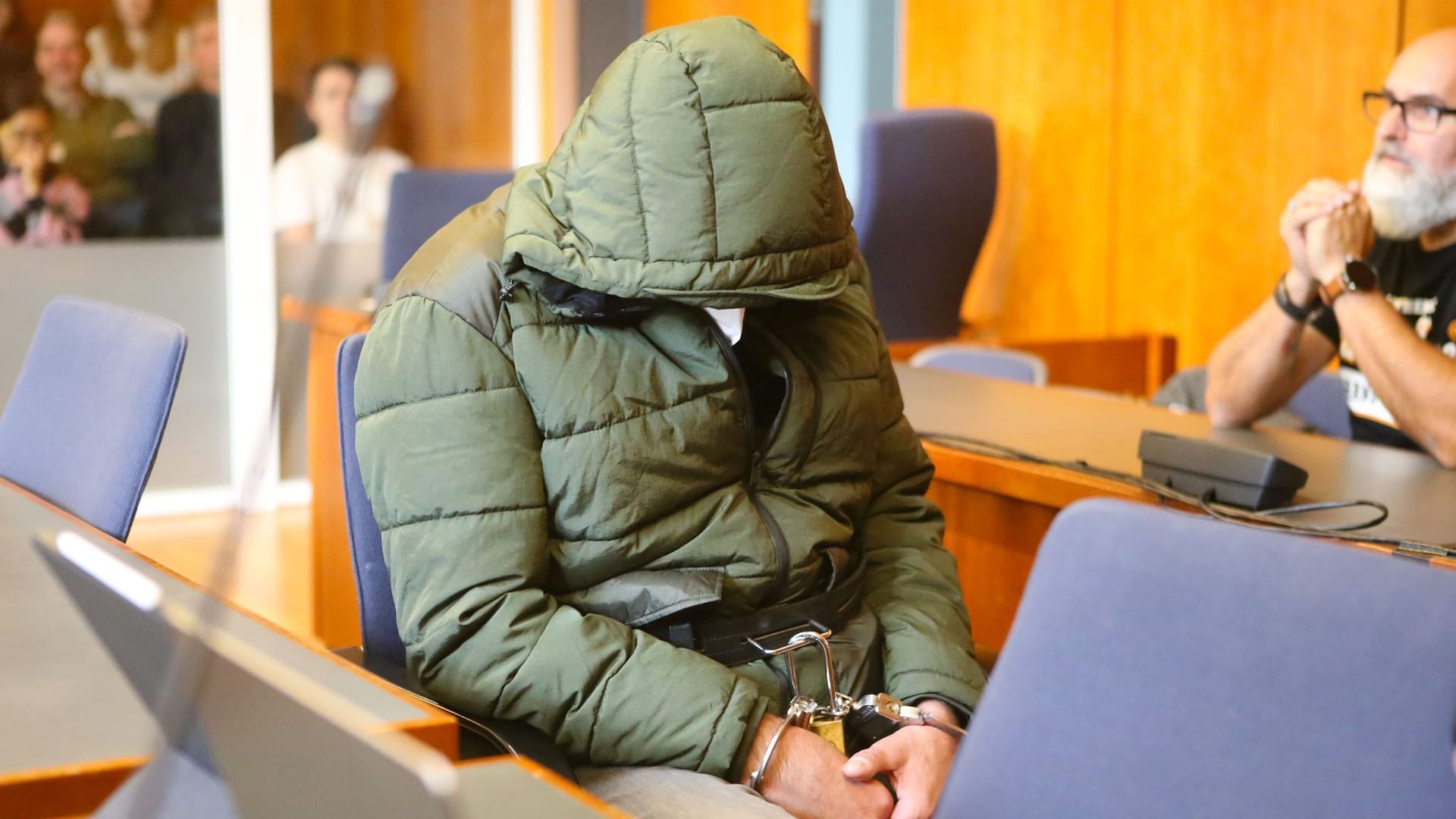 Der Angeklagte sitzt mit Handschellen in einem Saal des Landgerichts Göttingen.