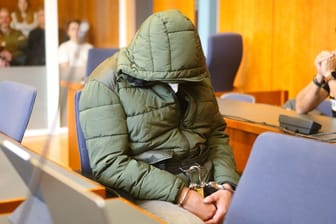 Der Angeklagte sitzt mit Handschellen in einem Saal des Landgerichts Göttingen.