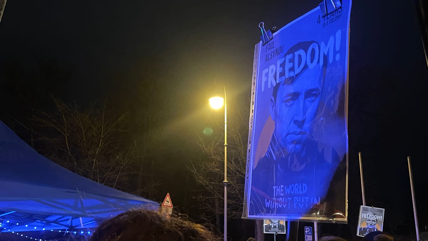 "Freiheit": Das Schild eines Teilnehmers im Schein des Blaulichts. Die Polizei ist vor Ort, um die Kundgebung vor potenziellen Gefährdern zu schützen.