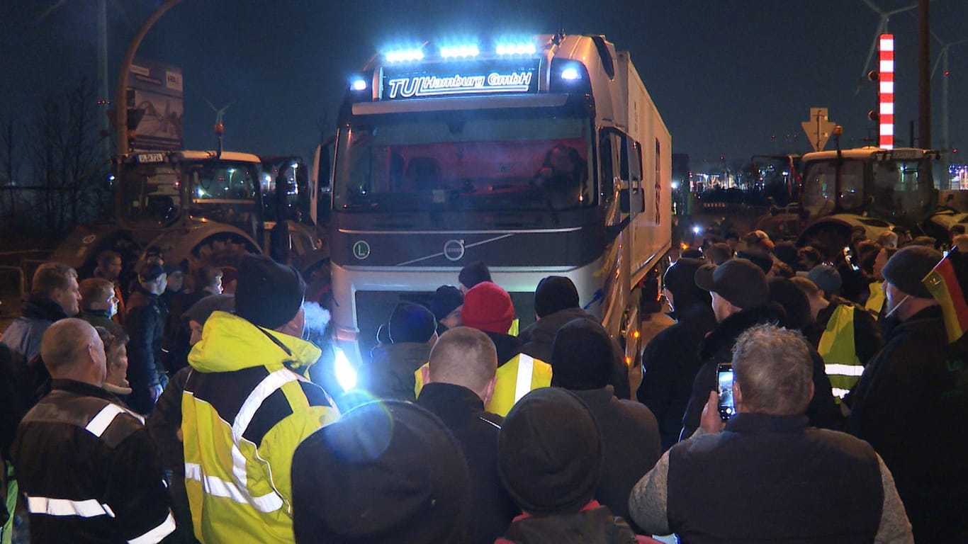 Ein LKW steckt in der Blockade von Landwirten auf einer Kreuzung mit Zufahrt zum Hafen im Süden von Hamburg: Die Bauernproteste hielten auch in der Nacht zum Dienstag an.