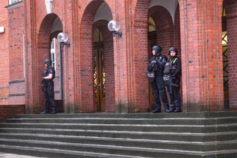 Schwerbewaffnete Beamte stehen vor dem Schulgebäude: Die Polizei sperrte den Bereich großräumig ab.
