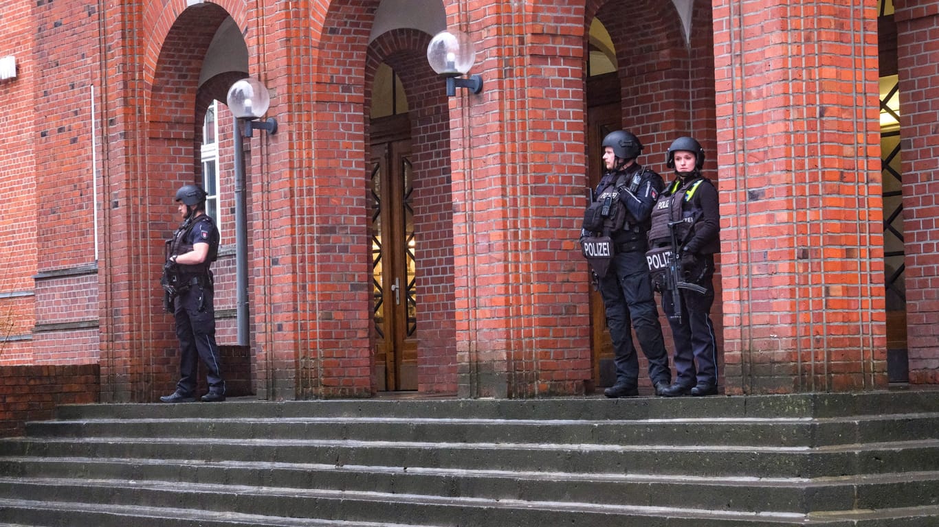 Schwerbewaffnete Beamte stehen vor dem Schulgebäude: Die Polizei sperrte den Bereich großräumig ab.