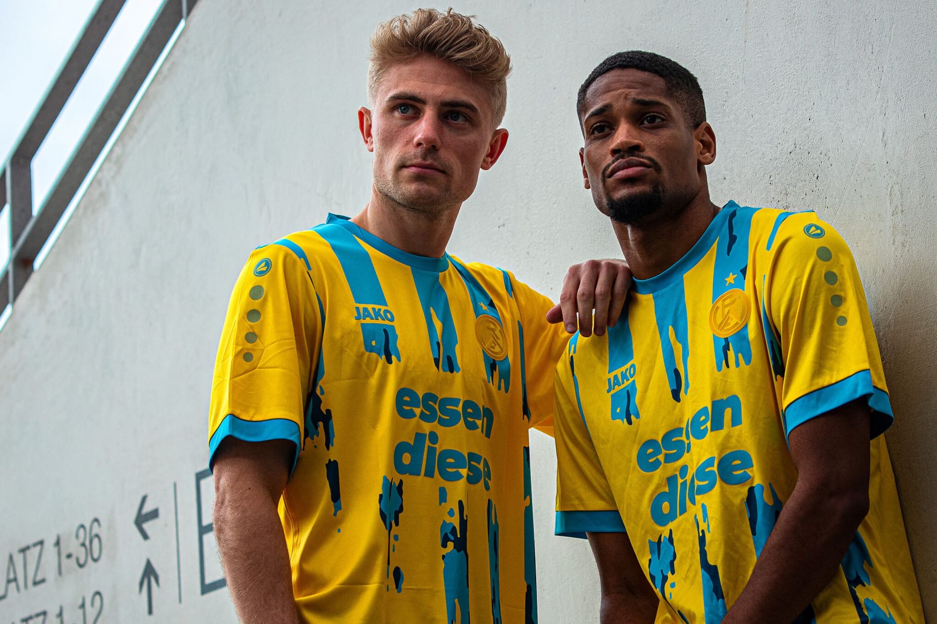 Cedric Harenbrock und Isaiah Young von Rot-Weiss Essen tragen das Sondertrikot in Stadtfarben.