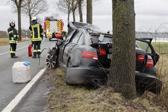 Feuerwehrleute stehen an der Unfallstelle. Beim Zusammenstoß zweier Autos im Landkreis Osnabrück ist eine Frau ums Leben gekommen.