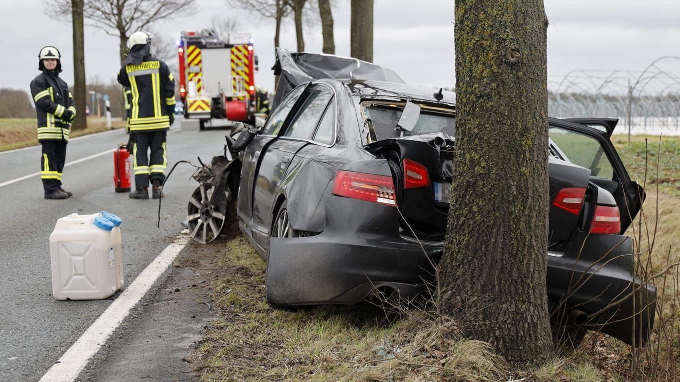 Feuerwehrleute stehen an der Unfallstelle. Beim Zusammenstoß zweier Autos im Landkreis Osnabrück ist eine Frau ums Leben gekommen.