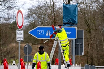 Mitarbeiter bringen ein rotes Kreuz am Autobahnschild der A27 an: Für mehrere Wochen geht auf dem Teilstück nichts mehr.