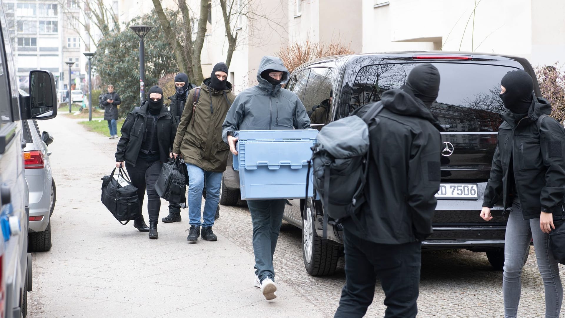 Polizisten durchsuchen im Stadtteil Kreuzberg eine Wohnung in einem Mehrfamilienhaus.