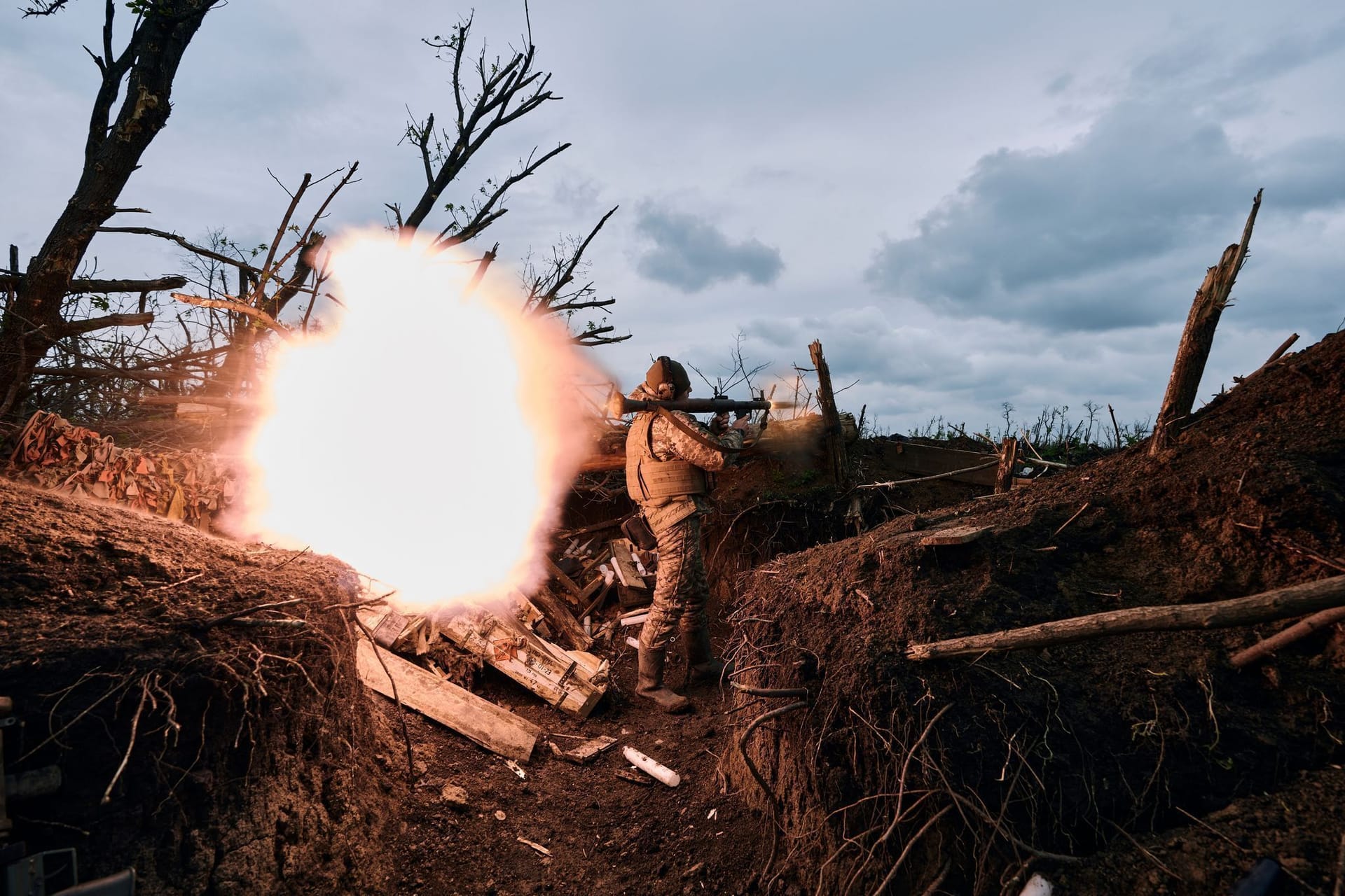Ein ukrainischer Soldat feuert auf russische Stellungen an der Front bei Awdijiwka.