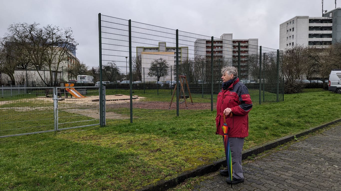 Silvia Loch steht in Frankfurt-Schwanheim vor dem Gelände, auf dem gebaut werden soll