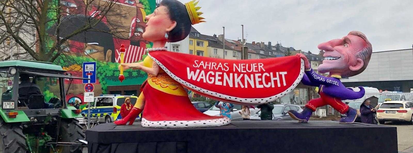 "Sahras neuer Wagenknecht" steht auf dem Umhang der Karikatur der Politikerin. Getragen von Düsseldorfs Ex-Oberbürgermeister Thomas Geisel, der die SPD verließ und bei Wagenknechts neuer Partei anheuerte.