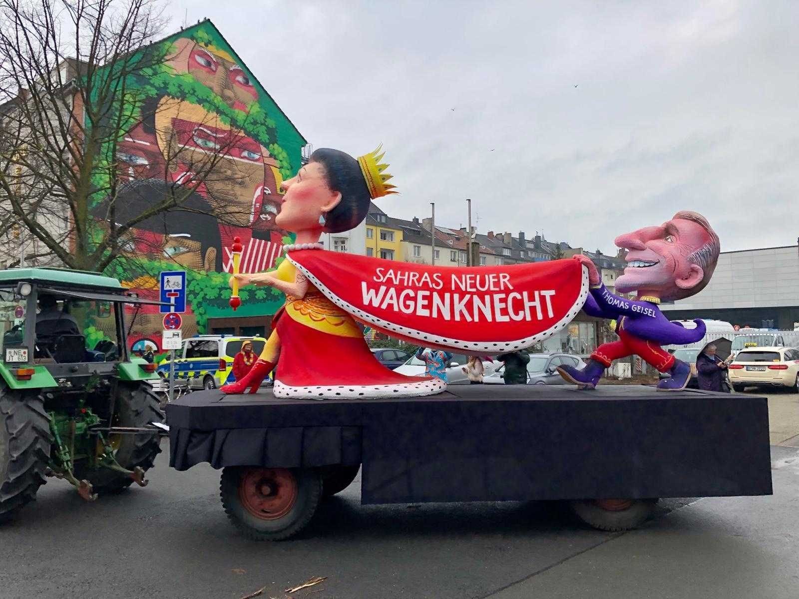 "Sahras neuer Wagenknecht" steht auf dem Umhang der Karikatur der Politikerin. Getragen von Düsseldorfs Ex-Oberbürgermeister Thomas Geisel, der die SPD verließ und bei Wagenknechts neuer Partei anheuerte. "Sahras neuer Wagenknecht" steht auf dem Umhang der Karikatur der Politikerin. Getragen von Düsseldorfs Ex-Oberbürgermeister Thomas Geisel, der die SPD verließ und bei Wagenknechts neuer Partei anheuerte.