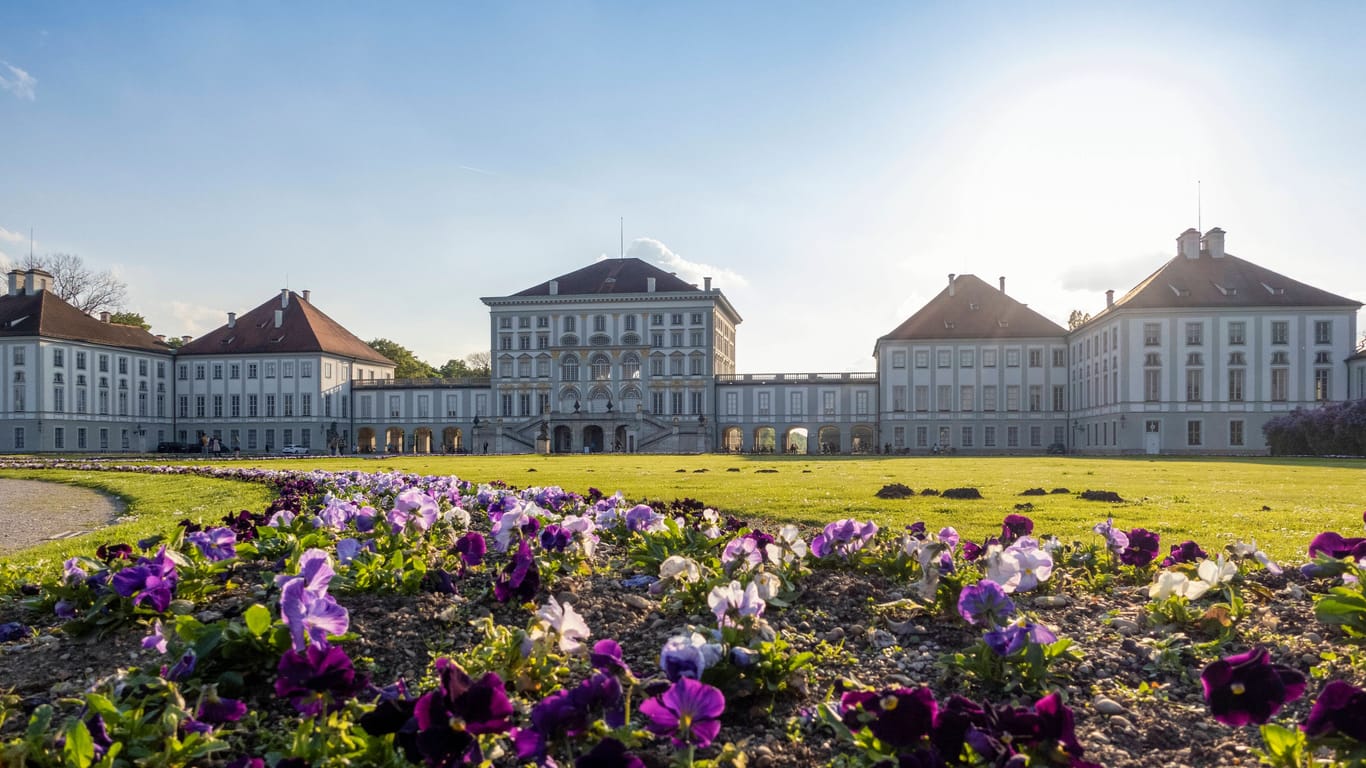 Blumen blühen vor Schloss Nymphenburg in München (Archivbild): Am Wochenende traut sich die Sonne fast in ganz Bayern hervor.