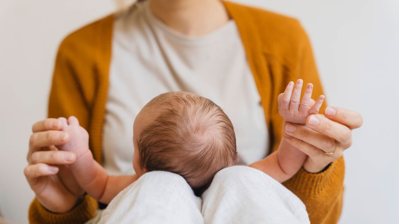 Ein Säugling auf dem Schoß seiner Mutter (Symbolbild): Das Baby in den USA hat einen seltenen Gendefekt.