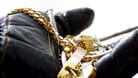 Ein Dieb hält Schmuck in der Hand (Symbolbild): Unbekannte haben ein Juweliergeschäft in Berlin-Schmargendorf überfallen.