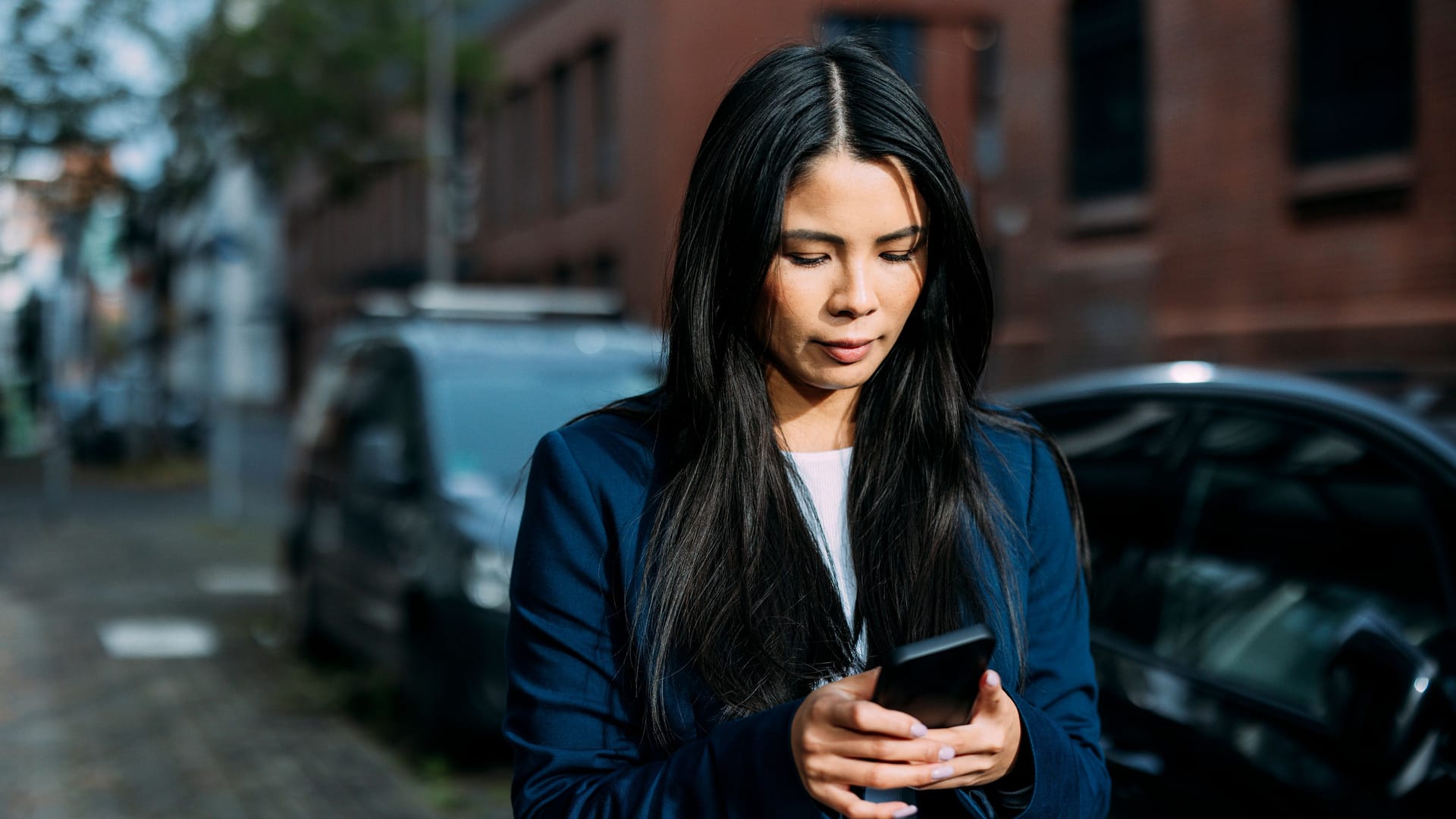 Frau mit einem Smartphone (Symbolfoto): Eine Dresdnerin ist eine enorme Summe geraubt worden.