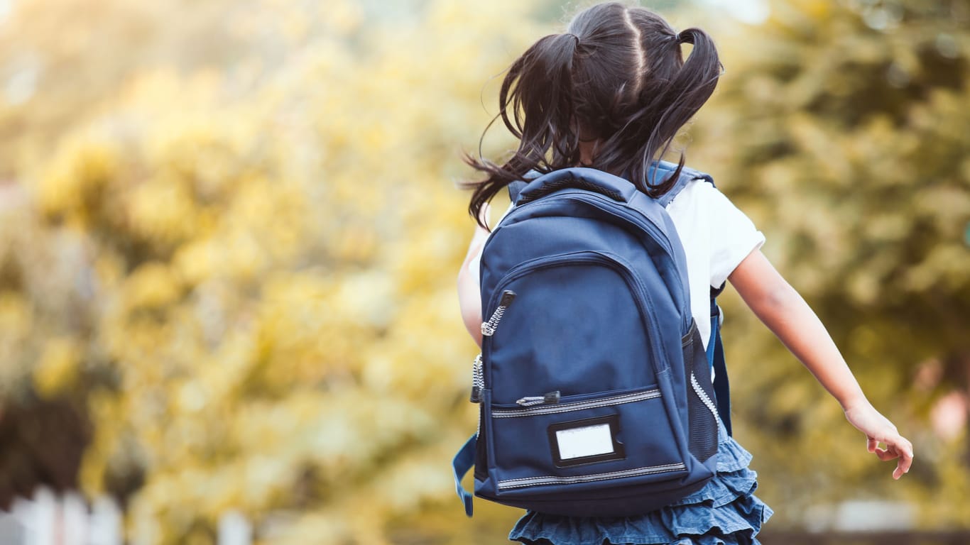Ein Mädchen läuft mit einem Rucksack (Symbolbild): Vor einer Grundschule sollen Männer versucht haben, ein Kind in ihr Auto zu locken.