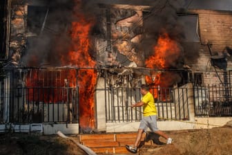In der chilenischen Stadt Vina del Mar versucht ein Anwohner, sein Haus zu retten: Bei verheerenden Waldbränden sind über 100 Menschen gestorben.
