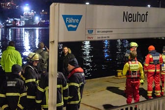Feuerwehrleute stehen am Anleger Neuhof: In der Hamburger Elbe suchten Taucher nach dem vermissten Kapitän. Er wurde am nächsten Tag tot geborgen.