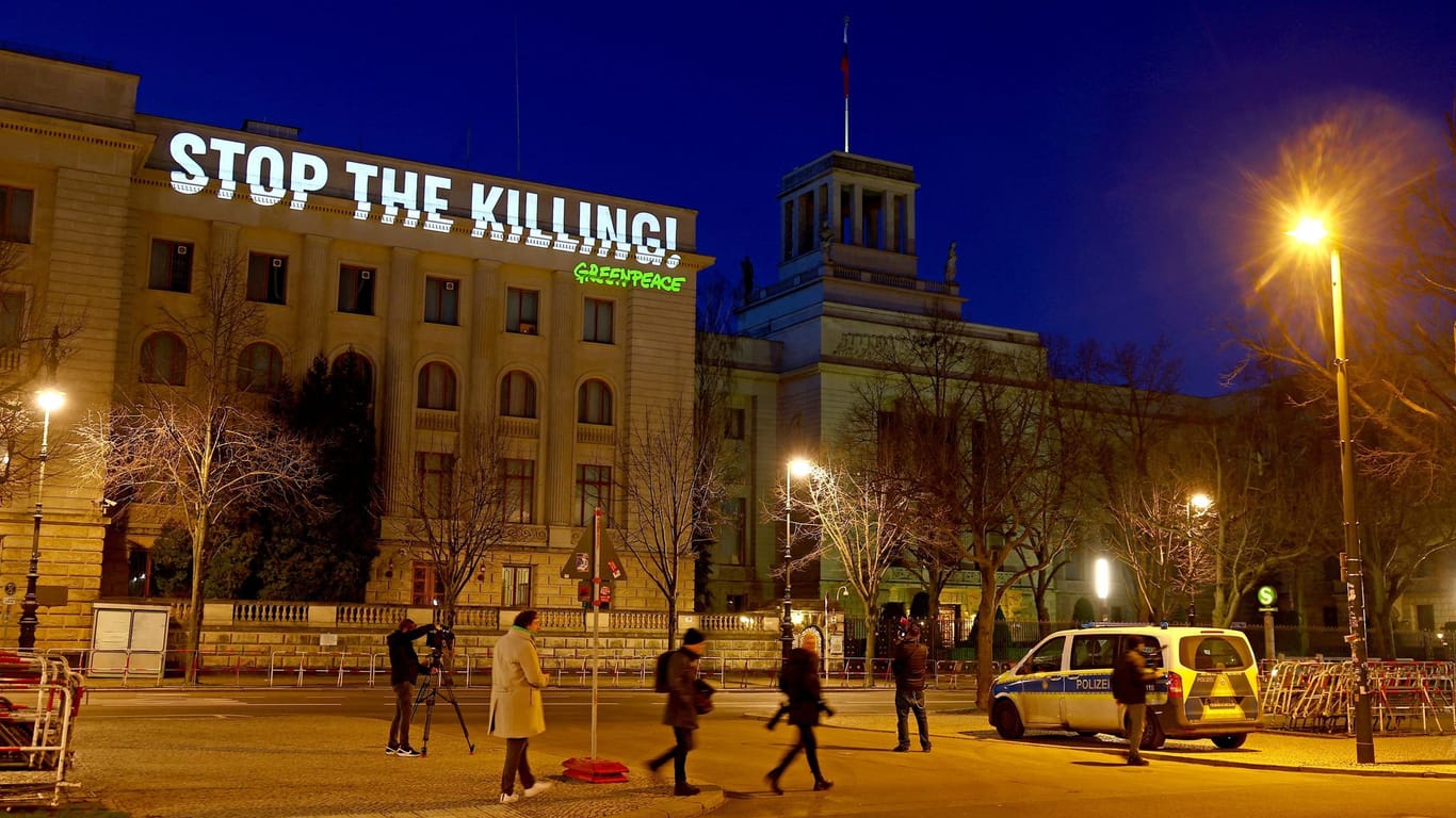 People cross a road as Greenpeace activists set up a protest projection onto the Russian embassy, marking the second anniversary of the Russian invasion of Ukraine, in Berlin, Germany February 24, 2024.
