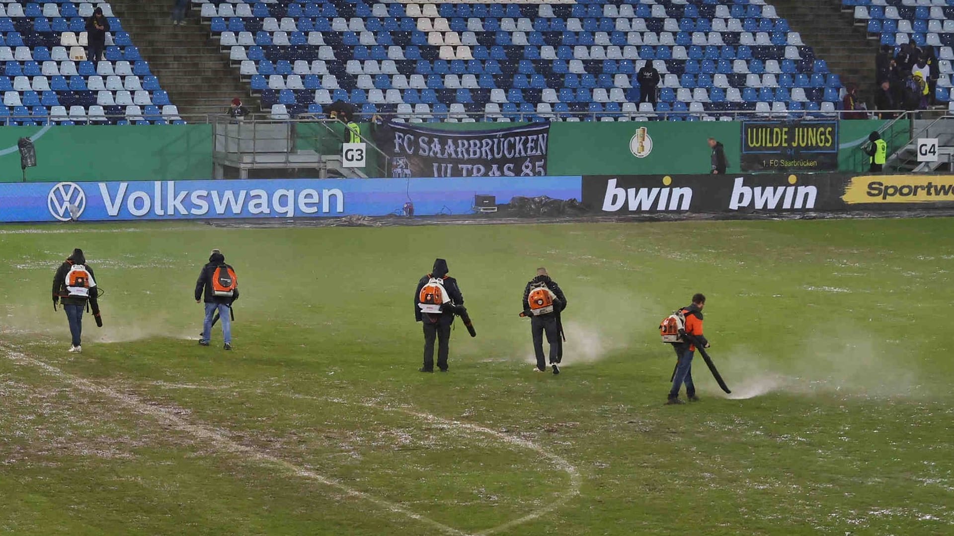 Trocknungsversuche in Saarbrücken: Starke Regenfälle bedrohen das DFB-Pokalspiel gegen Gladbach.