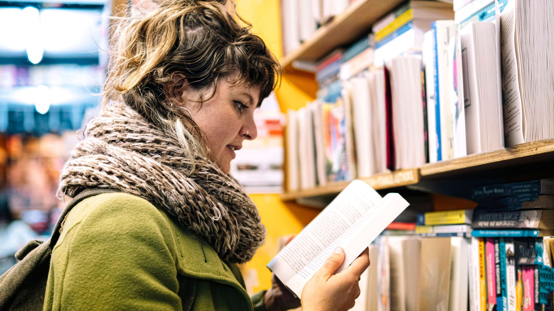 Eine Frau liest in einem Buch (Symbolbild): In Hannover muss die Stadtbibliothek sparen.