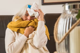 Krank auf der Couch: Die Grippewelle in Deutschland geht weiter.